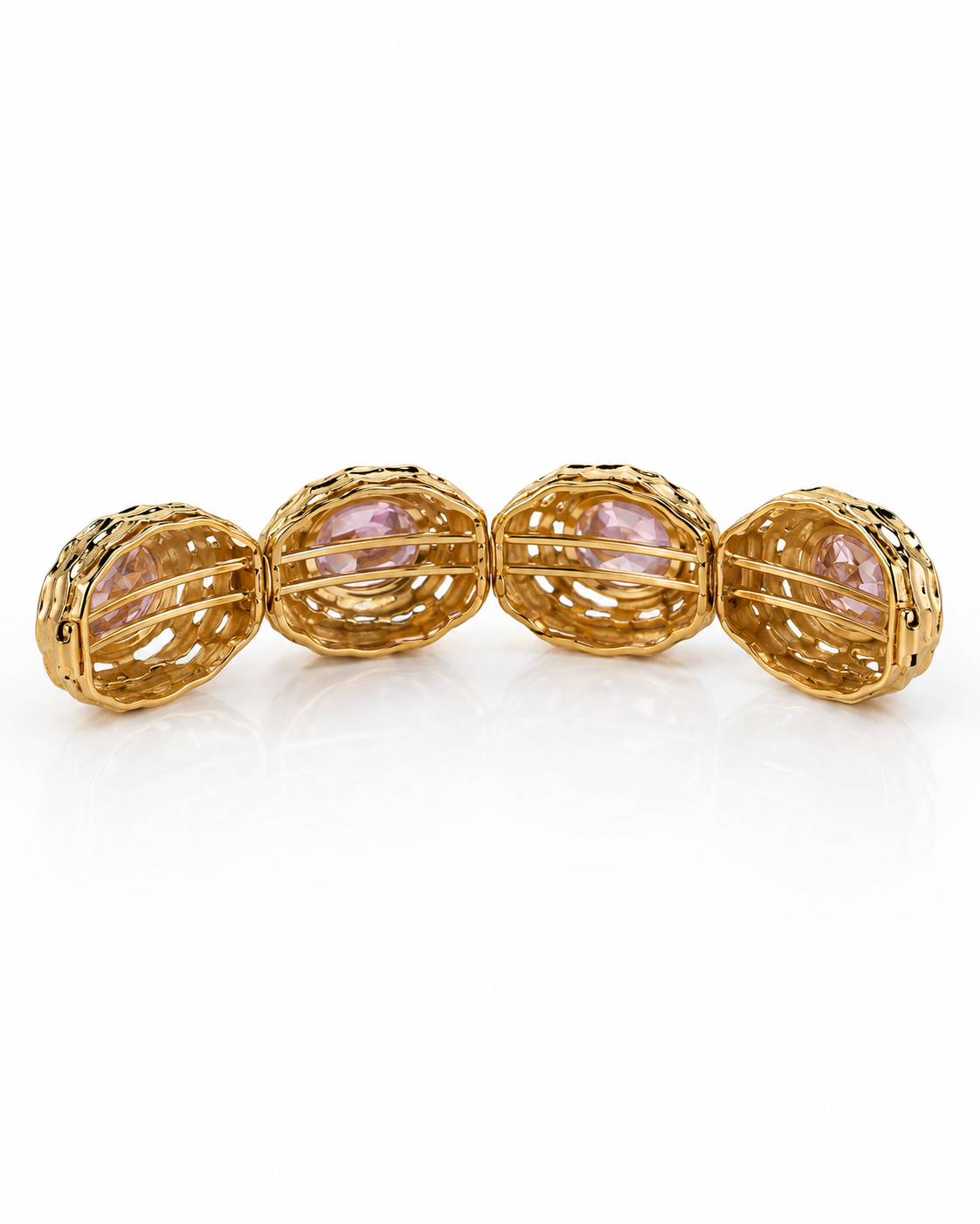 A gold filigree cuff bracelet featuring four oval bezel-set light purple amethyst gemstones, displayed on a clean white background.
